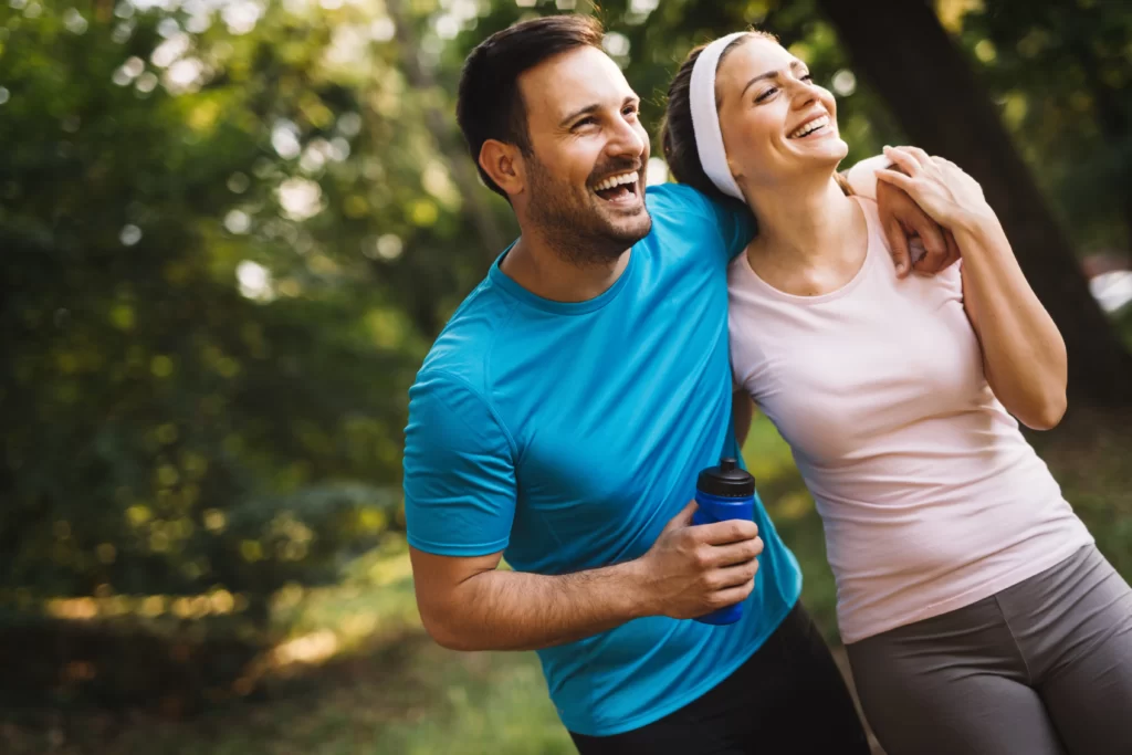 smiling couple exercising together outdoors in sun utc